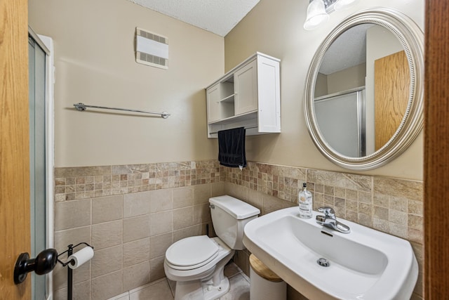 620 Acacia Dr S, Annandale, MN 55302 - full bath featuring tile walls, a shower with door, a wainscoted wall, a textured ceiling, and tile patterned floors