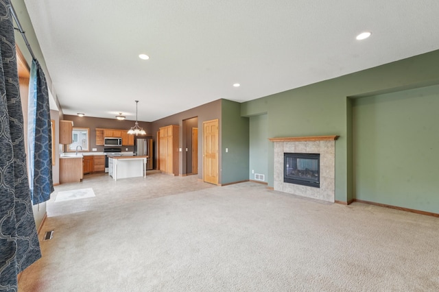 936 Waterford Way, Jordan, MN 55352 - unfurnished living room featuring a tile fireplace, light carpet, and recessed lighting