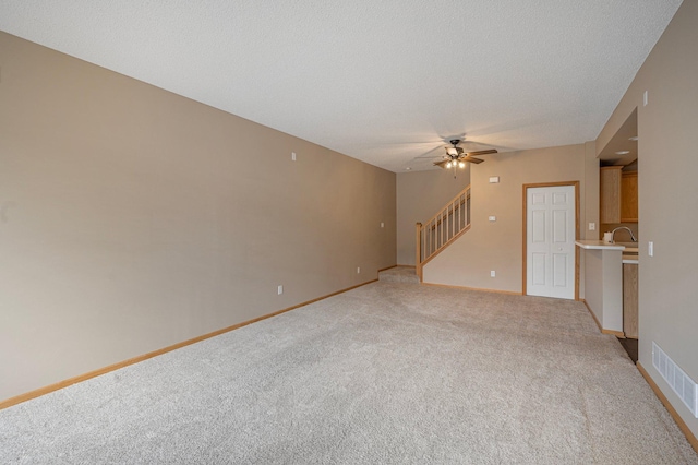 1471 111th Dr NE Unit B, Blaine, MN 55449 - unfurnished living room featuring light colored carpet, stairs, ceiling fan, and a textured ceiling