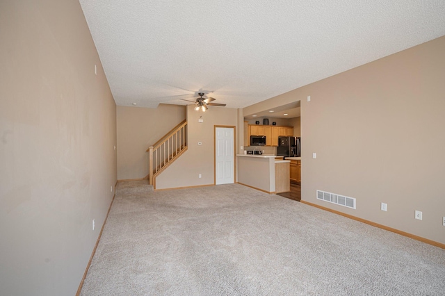 1471 111th Dr NE Unit B, Blaine, MN 55449 - unfurnished living room with stairs, ceiling fan, light colored carpet, and a textured ceiling
