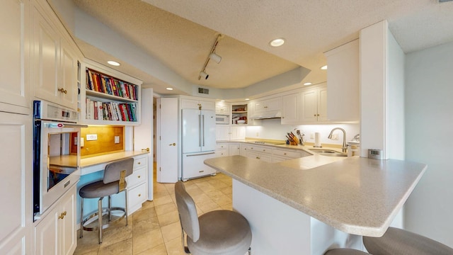 600 4th St SW Unit 401, Rochester, MN 55902 - kitchen with white appliances, open shelves, a peninsula, a breakfast bar, and light countertops