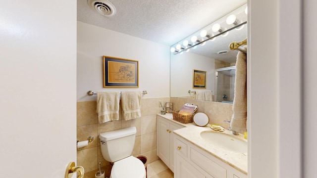 600 4th St SW Unit 401, Rochester, MN 55902 - full bathroom with vanity, a shower with door, tile walls, a textured ceiling, and tile patterned flooring