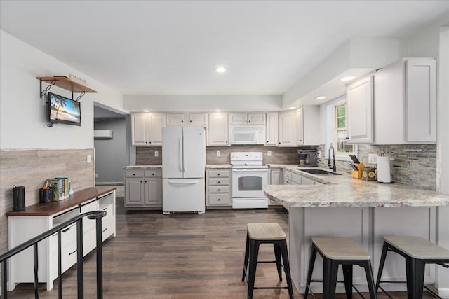 E633 950th Ave, Stanton Twp, WI 54734 - kitchen with white appliances, a peninsula, a breakfast bar, dark wood-type flooring, and backsplash