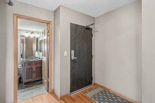 78 10th St E Unit 2901, Saint Paul, MN 55101 - bathroom featuring a textured ceiling, a shower, wood finished floors, and vanity