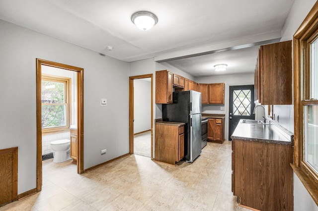4242 Zane Ave N, Crystal, MN 55422 - kitchen featuring stainless steel appliances, brown cabinetry, healthy amount of natural light, and dark countertops