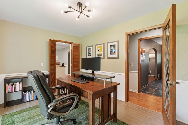 2125 Innsbruck Pkwy, Columbia Heights, MN 55421 - office area with wood finished floors, a chandelier, and arched walkways