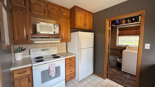 804 17th St SW, Austin, MN 55912 - kitchen featuring white appliances, washer / clothes dryer, under cabinet range hood, and light countertops