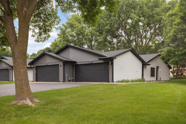 8824 134th St W, Apple Valley, MN 55124 - mid-century modern home with an attached garage, asphalt driveway, a front lawn, and roof with shingles