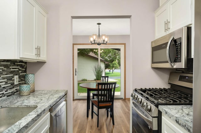 8824 134th St W, Apple Valley, MN 55124 - kitchen featuring stainless steel appliances, light wood-type flooring, a chandelier, backsplash, and white cabinets
