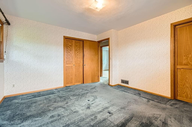 53 Morningside Dr, Saint Paul, MN 55119 - unfurnished bedroom with wallpapered walls, carpet floors, and a closet