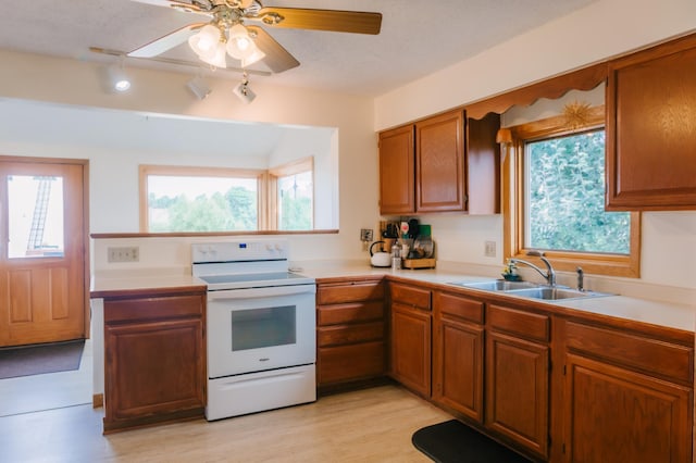 2834 150th St, Luck, WI 54837 - kitchen featuring white electric range oven, light countertops, brown cabinets, and plenty of natural light