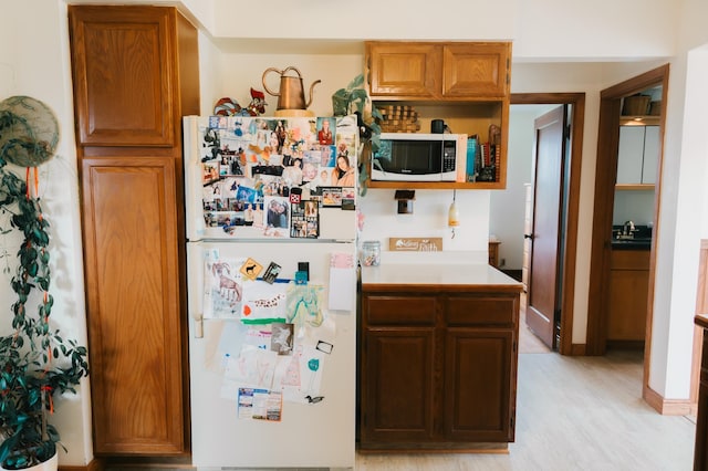 2834 150th St, Luck, WI 54837 - kitchen with white appliances, open shelves, light countertops, light wood-style flooring, and brown cabinets
