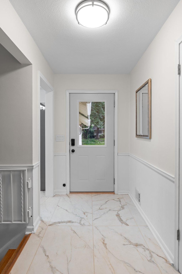 715 Forest Dale Rd, New Brighton, MN 55112 - doorway to outside with marble finish floors and a textured ceiling