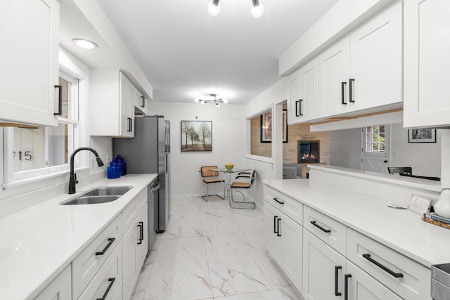 715 Forest Dale Rd, New Brighton, MN 55112 - kitchen featuring light marble finish flooring, white cabinetry, and a lit fireplace