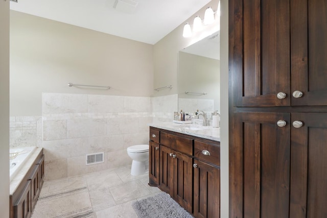 369 144th Ln NW, Andover, MN 55304 - full bath featuring tile walls, vanity, a bath, a wainscoted wall, and tile patterned floors