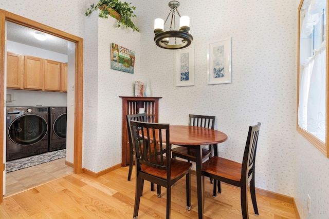 1978 110th Ct NE Unit 1103, Blaine, MN 55449 - dining area featuring independent washer and dryer, a chandelier, wallpapered walls, and light wood finished floors