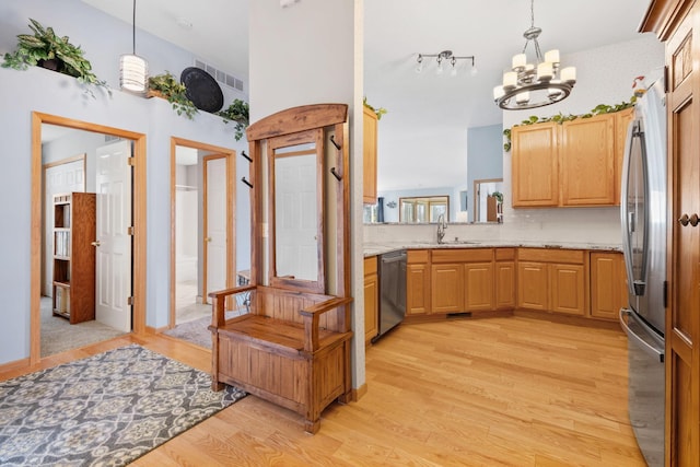 1978 110th Ct NE Unit 1103, Blaine, MN 55449 - kitchen featuring stainless steel appliances, a chandelier, light wood-type flooring, decorative backsplash, and pendant lighting