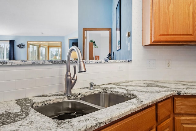 1978 110th Ct NE Unit 1103, Blaine, MN 55449 - kitchen view of light stone counters, decorative backsplash, and brown cabinets
