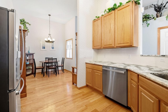 1978 110th Ct NE Unit 1103, Blaine, MN 55449 - kitchen with stainless steel appliances, light wood finished floors, a chandelier, wallpapered walls, and hanging light fixtures