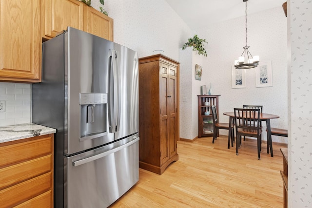 1978 110th Ct NE Unit 1103, Blaine, MN 55449 - kitchen with stainless steel fridge, a chandelier, light wood-type flooring, wallpapered walls, and lofted ceiling