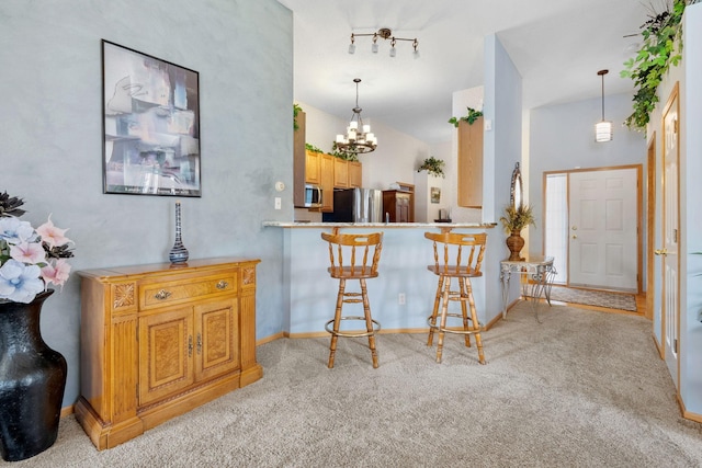 1978 110th Ct NE Unit 1103, Blaine, MN 55449 - kitchen with appliances with stainless steel finishes, light carpet, a chandelier, a breakfast bar area, and pendant lighting
