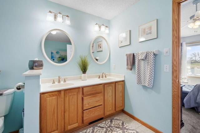 1978 110th Ct NE Unit 1103, Blaine, MN 55449 - ensuite bathroom featuring double vanity, a textured ceiling, a ceiling fan, and tile patterned flooring