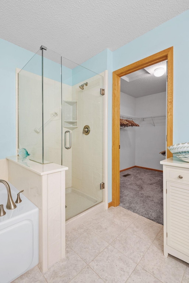 1978 110th Ct NE Unit 1103, Blaine, MN 55449 - full bathroom with a stall shower, a bath, a walk in closet, tile patterned floors, and a textured ceiling