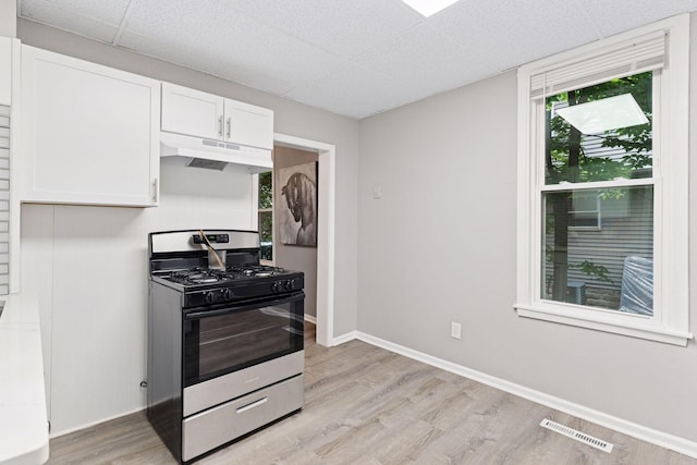 59 Winnipeg Ave, Saint Paul, MN 55117 - kitchen featuring stainless steel gas range, under cabinet range hood, white cabinetry, light wood-type flooring, and a paneled ceiling
