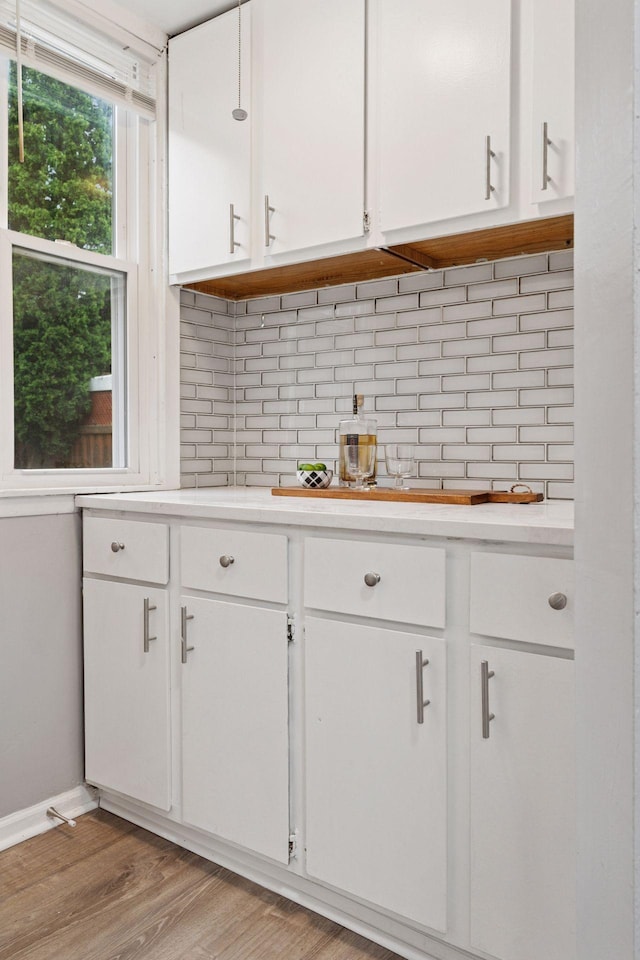 59 Winnipeg Ave, Saint Paul, MN 55117 - kitchen with white cabinets, light countertops, decorative backsplash, and light wood-style floors