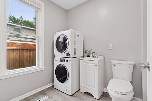 59 Winnipeg Ave, Saint Paul, MN 55117 - washroom featuring stacked washer / drying machine and light wood finished floors