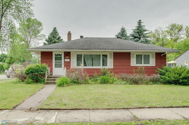 1021 1st St S, Moorhead, MN 56560 - view of front facade with a chimney, a front yard, and roof with shingles