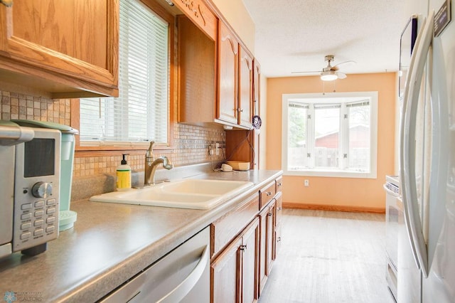 1021 1st St S, Moorhead, MN 56560 - kitchen with white appliances, a ceiling fan, backsplash, and light countertops