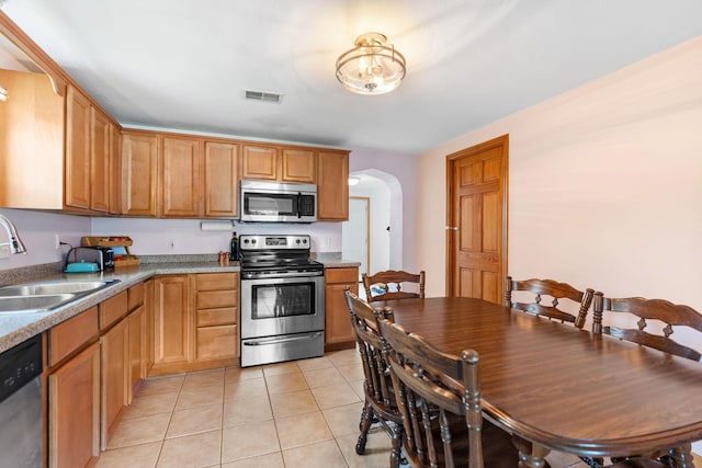 500 Cartway Rd, Champlin, MN 55316 - kitchen with appliances with stainless steel finishes, arched walkways, and light tile patterned floors