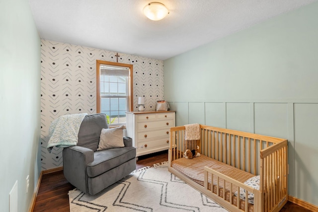 500 Cartway Rd, Champlin, MN 55316 - bedroom featuring wallpapered walls, wood finished floors, a wainscoted wall, an accent wall, and a nursery area