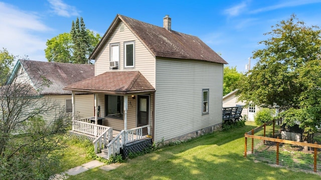 312 5th Ave, Bovey, MN 55709 - rear view of house with a porch, a lawn, a chimney, cooling unit, and roof with shingles