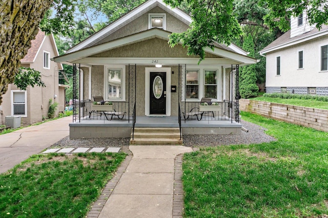 242 Winona St W, West Saint Paul, MN 55118 - view of front of home featuring covered porch, a front lawn, and stucco siding