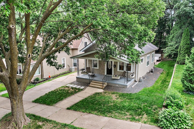 242 Winona St W, West Saint Paul, MN 55118 - view of front of house featuring stucco siding, covered porch, a front lawn, and roof with shingles