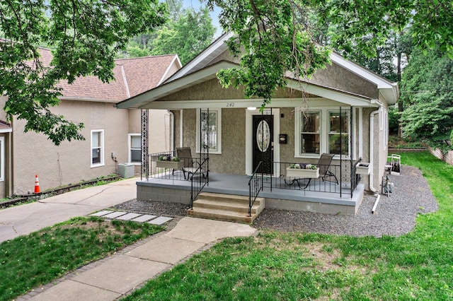 242 Winona St W, West Saint Paul, MN 55118 - view of front of property with stucco siding, a porch, a shingled roof, and a front yard