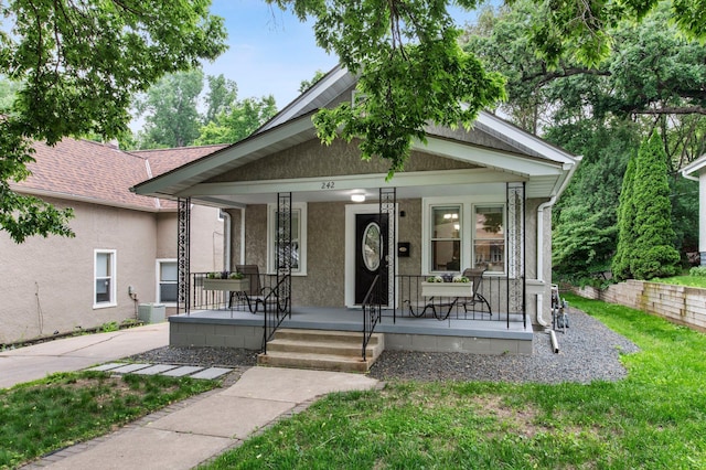 242 Winona St W, West Saint Paul, MN 55118 - view of front of home featuring stucco siding, a porch, a front lawn, and a shingled roof