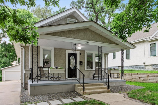242 Winona St W, West Saint Paul, MN 55118 - view of front of house featuring covered porch, an outdoor structure, stucco siding, and a garage
