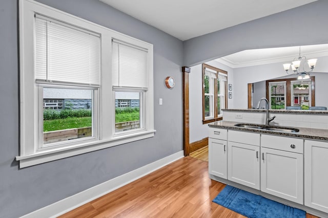 242 Winona St W, West Saint Paul, MN 55118 - kitchen featuring light wood-type flooring, a chandelier, dark stone counters, white cabinets, and pendant lighting