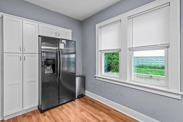 242 Winona St W, West Saint Paul, MN 55118 - kitchen with stainless steel fridge, light wood-type flooring, and white cabinets