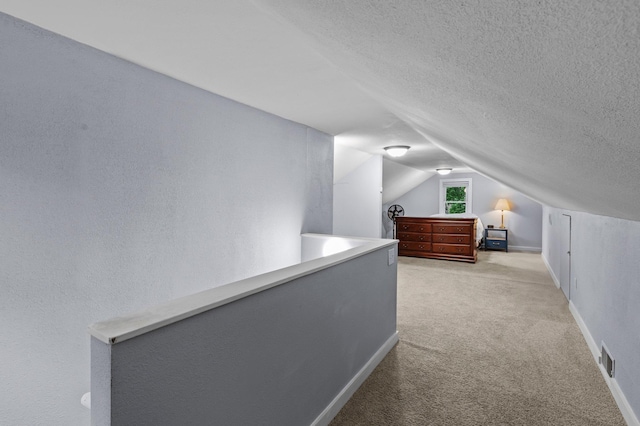 242 Winona St W, West Saint Paul, MN 55118 - unfurnished bedroom featuring light colored carpet, vaulted ceiling, and a textured ceiling