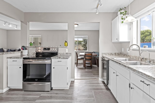 1824 4th Ave S, Minneapolis, MN 55404 - kitchen with electric range, track lighting, white cabinets, and light wood-style floors
