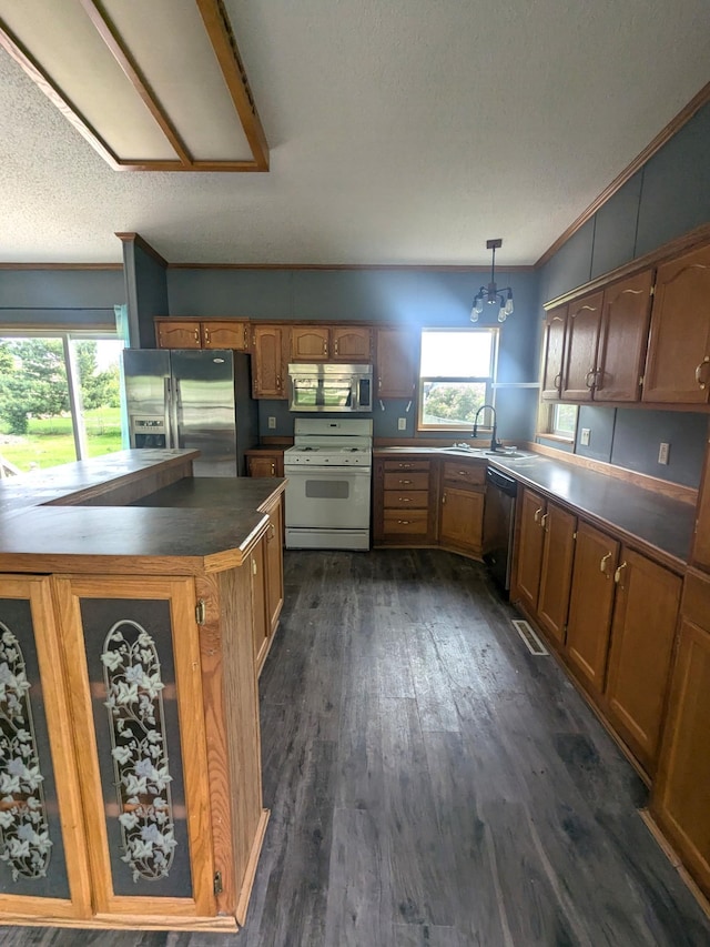 204 6th St W, Carlos, MN 56319 - kitchen with stainless steel appliances, dark countertops, dark wood-style floors, brown cabinetry, and ornamental molding