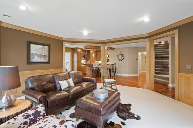 6300 78th Ln, Greenfield, MN 55357 - living area with crown molding, stairway, wainscoting, wood finished floors, and ornate columns