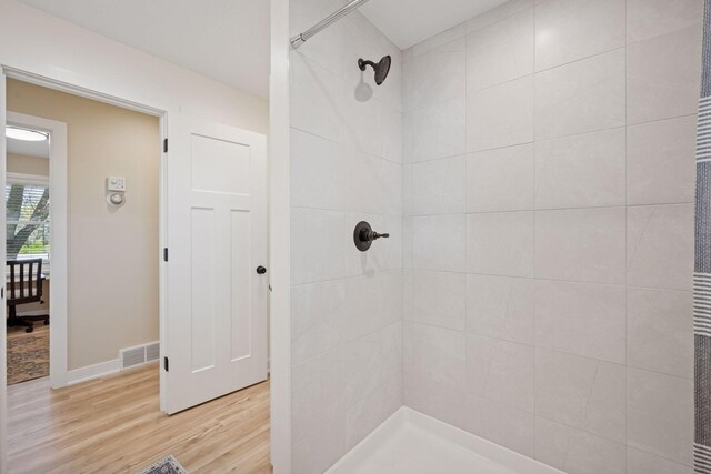 6676 Jason Ave NE, Monticello, MN 55362 - bathroom featuring a tile shower and wood finished floors