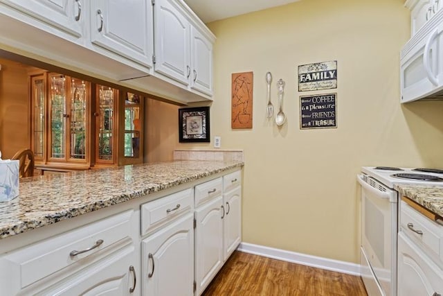 35 Nathan Ln N Unit 104, Plymouth, MN 55441 - kitchen featuring white appliances, light wood-type flooring, white cabinets, and light stone counters