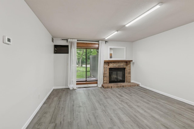 385 Shelard Pkwy Unit 103, Saint Louis Park, MN 55426 - unfurnished living room featuring wood finished floors and a brick fireplace