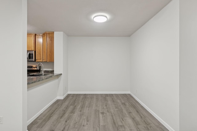 385 Shelard Pkwy Unit 103, Saint Louis Park, MN 55426 - unfurnished dining area featuring a sink and light wood-style flooring